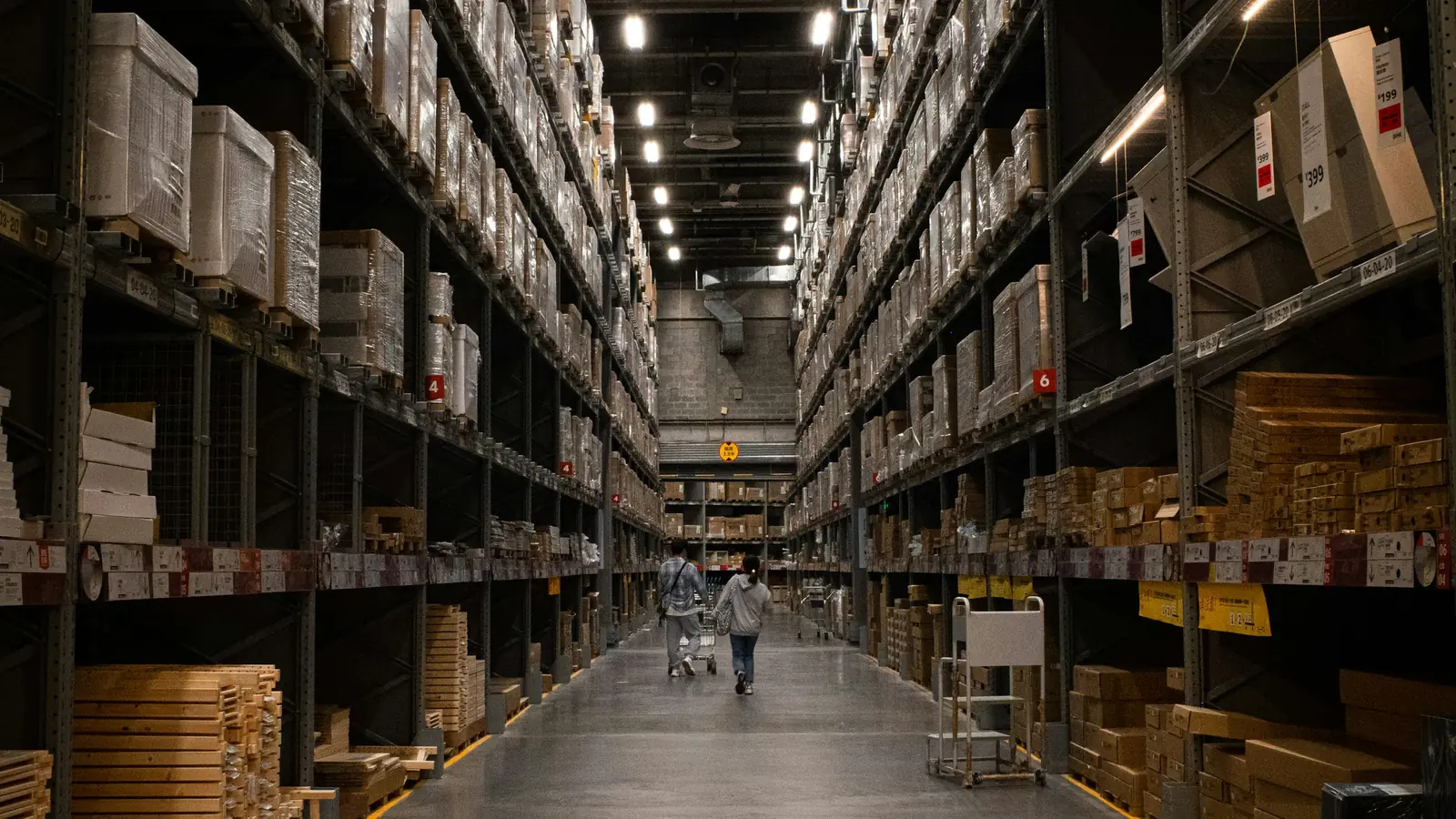 A long warehouse aisle lined with racked cartons